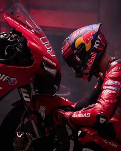 a man in red leather gear sitting on a motorcycle