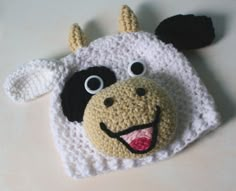 a crocheted cow hat with eyes and nose