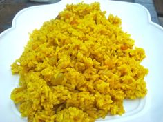 a white plate topped with yellow rice on top of a table