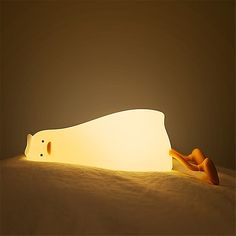 a lamp that is shaped like a dog laying on the ground with it's head down