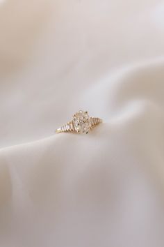 a diamond ring sitting on top of a white cloth