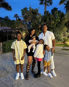 a family poses for a photo in front of palm trees