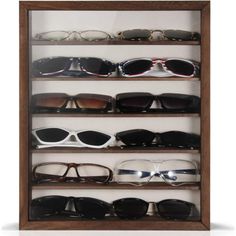 a display case with many pairs of sunglasses on it's sides and two rows of glasses in the middle