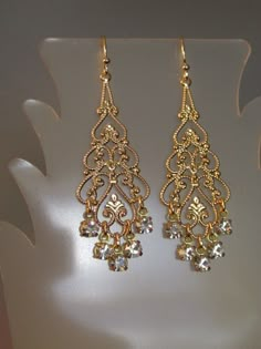 "Swarovski Crystal Filigree Earring Swarovski Crystal rhinestone filigree earrings. These stunning earrings feature large gold plated filigree with Swarovski Crystal rhinestone dangles. Earrings approximate length of 2 1/2\" from top of goldplated earwires and a width of 3/4\" across widest part. Arrives gift boxed. If you are looking for lightweight earrings that make a big statement, these earrings are for you! Perfect for the bride, bridesmaids, or that special occasion - an elegant and timel Bride Earring, Big Earrings Gold, Faberge Jewelry, Gold Filigree Earrings, Bride Earrings, Crystal Dangle Earrings, Earring Gold, Filigree Earrings, Jewelry Fashion Trends