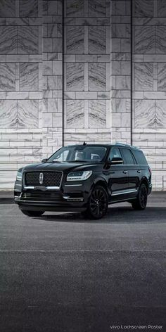 a black suv parked in front of a wall