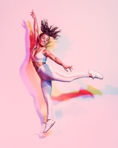 a woman is jumping in the air with her legs spread out and she has long hair