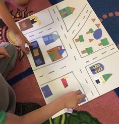 two children are playing with paper cutouts on the floor