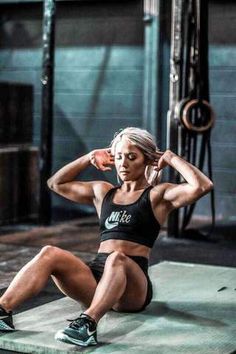 a woman sitting on the ground with her hands behind her head