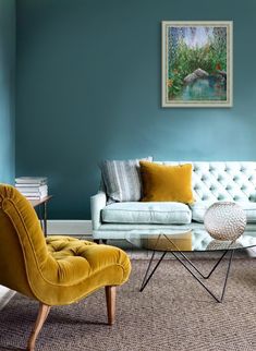 a living room with blue walls and yellow chairs