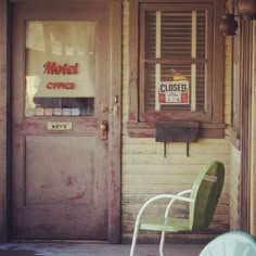 a green chair sitting in front of a closed door with a sign that reads motel office