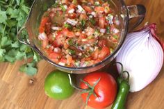 a bowl filled with salsa next to some vegetables