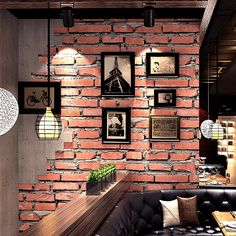 a living room filled with furniture next to a brick wall covered in pictures and framed photos