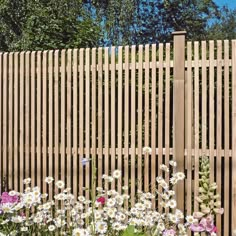 a wooden fence with white and pink flowers in the foreground