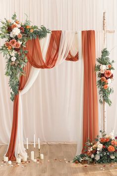 the wedding arch is decorated with orange and white flowers, greenery, and candles