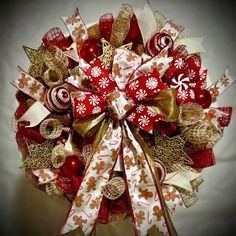 a red and gold christmas wreath with candy canes, bows and ornaments on it