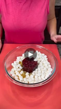 a woman sitting at a table with a bowl of food in front of her,