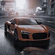 an orange sports car driving down a wet street