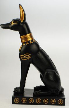 an egyptian style dog figurine on a black base with gold trimmings