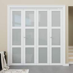 an empty room with white doors and carpet on the floor in front of a staircase