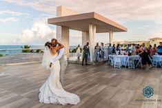 a bride and groom kissing in front of an ocean view wedding reception at the four seasons resort