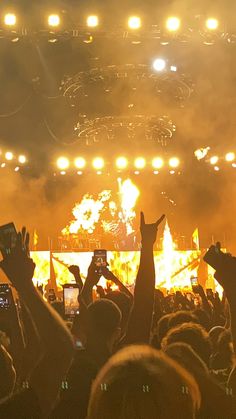 a crowd of people at a concert with their cell phones up in the air,