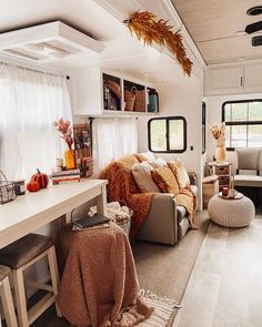 a living room filled with furniture next to a white table and window covered in curtains