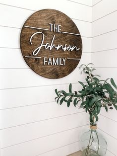 a wooden sign that says the johnson family on it next to a potted plant