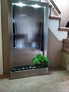 an indoor shower with plants and rocks in the bottom right hand corner, on carpeted stairs