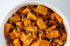 a white bowl filled with sweet potatoes and nuts