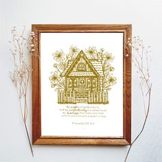 a framed print with a house surrounded by wildflowers on a white wall next to dried plants