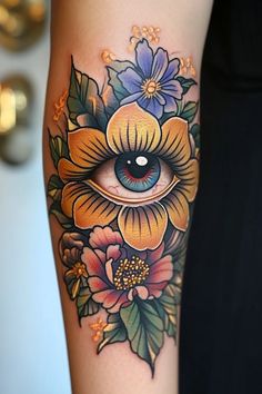 a woman's arm with flowers and an eye tattoo on the side of her leg