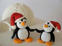 two penguins wearing santa hats on top of a cake