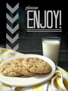 two cookies on a plate next to a glass of milk and a sign that says please enjoy