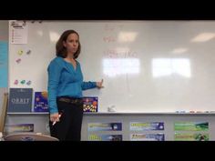 a woman standing in front of a white board