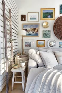 a bedroom with white walls and lots of pictures on the wall, including an old ladder