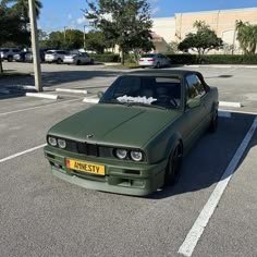 a green car parked in a parking lot