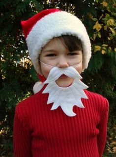 a young boy wearing a santa hat and fake beard