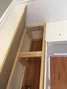 the bottom half of an unfinished closet with wood flooring