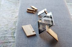 a small wooden object sitting on top of a couch next to a tablet computer and other items