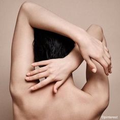 a nude woman with her hands on her back