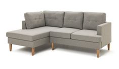 a gray couch sitting on top of a white floor next to a wooden leg chair