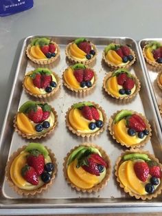 there are many cupcakes with fruit on them in the pan, ready to be eaten