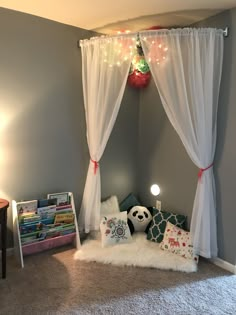 a child's bedroom decorated for christmas with white drapes and lights