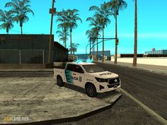 a police car parked on the side of a road next to palm trees and buildings