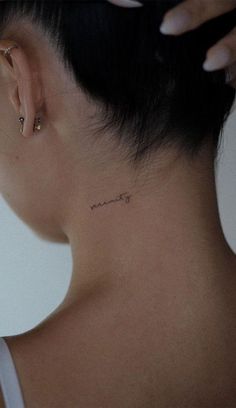 a woman with a small tattoo on her neck