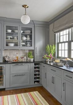 a kitchen with gray cabinets and wooden floors is featured in the color scheme for this image