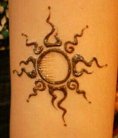 a woman's arm with a tattoo on it that has an image of a sun