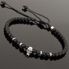 a black beaded bracelet with a silver skull charm