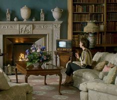 a woman sitting on a couch in front of a fire place