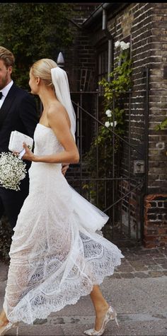 the bride and groom are walking down the street